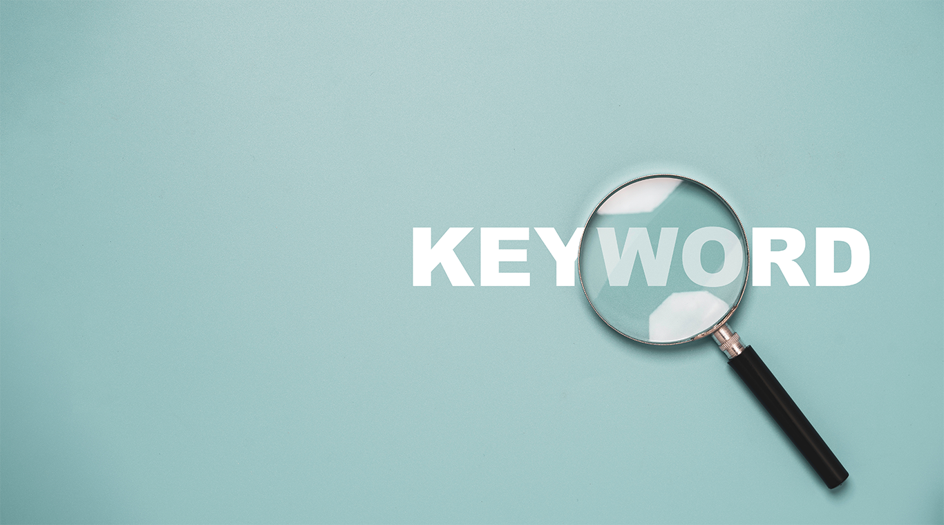Magnifying glass highlighting the word “keyword” on a blue background, representing keyword research and search analysis in digital marketing.