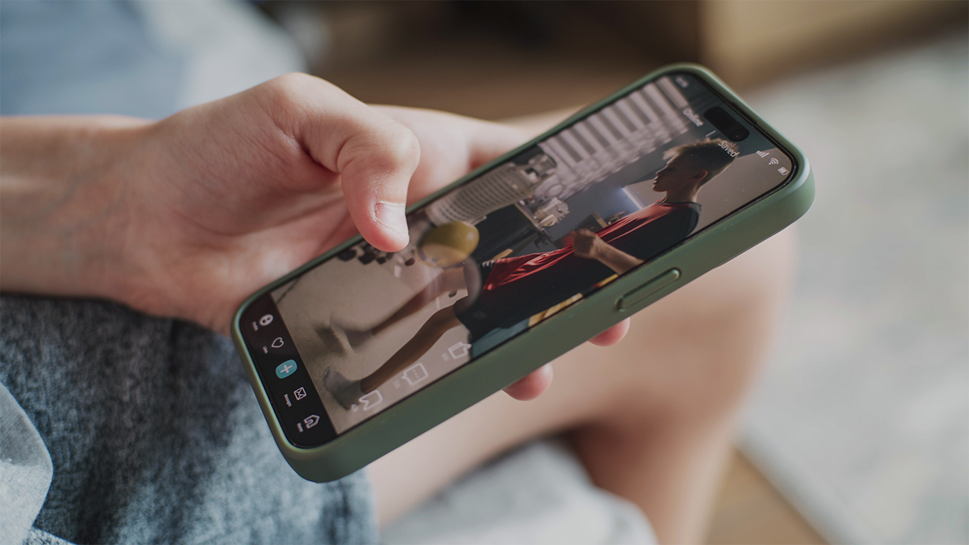 Person holding a smartphone and watching a short-form vertical video on a social media app, illustrating mobile video consumption and search-based video discovery.